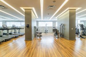 a gym with treadmills and machines in a room at Charming Downtown Condos by GLOBALSTAY in Toronto