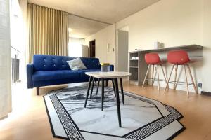 a living room with a blue couch and a table at Departamento con vista de Lima en San Borja in Lima