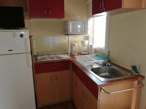 a small kitchen with a sink and a refrigerator at CAMPING 3* ! PROGHE DES GORGES DU VERDON ET LAC DE STE CROIX 04500 ! TOUT EQUIPE ! CHAMPS DE LAVANDES ! CALME ! NBRES ACTIVITES ! RANDONNEES ! NAUTISME ! in Sainte-Croix-de-Verdon +6 photos