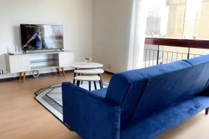 sala de estar con sofá azul y mesa en Departamento con vista de Lima en San Borja en Lima