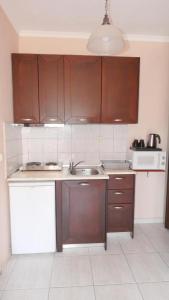 a kitchen with brown cabinets and a sink at House Chrysoula Mitsokopi in Sarti