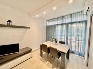 a dining room with a table and a large window at Premium Apartment Mono A1 in Marina di Bibbona