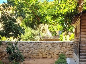 a stone wall in front of a tree at Ariadne Studio in Kyparissia