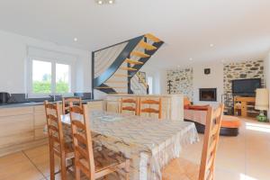 een keuken en een woonkamer met een tafel en een trap bij Gite Ville Marie in Andel