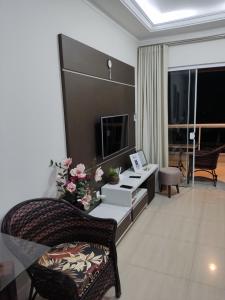 un soggiorno con divano e tavolo con fiori di Residencial Maristela a Bombinhas