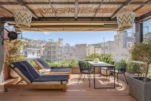 a patio with chairs and a table on a balcony at The Residence Christokopidou Hotel & Spa in Athens