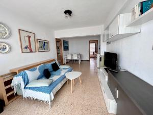 sala de estar con sofá y TV en Piso en el Puig: Frente al Mar, en El Puig
