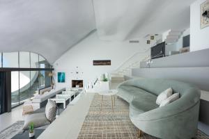 sala de estar con sofá verde y escaleras en RentitSpain Casa Acantilado, en Granada