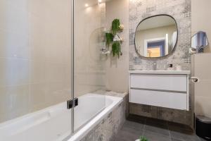 a bathroom with a tub and a mirror at King David Apartment - J&J in Jerusalem +158 photos