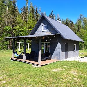eine kleine Hütte mit einer Veranda und einer Terrasse in der Unterkunft Leśny Reset in Mrągowo