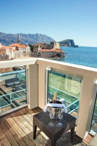 a table on a balcony with a view of the ocean at Avala Resort & Villas in Budva