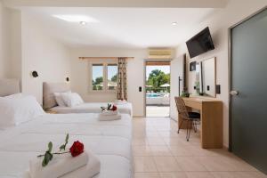 ein Wohnzimmer mit 2 Betten und einem Schreibtisch in einem Zimmer in der Unterkunft Santos Apartments & Studios in Dassia