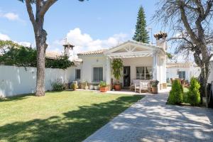 a white house with a patio and yard at La Perla Costera in Chiclana de la Frontera