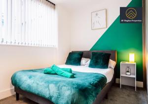 een groene en witte slaapkamer met een bed met groene lakens bij Two Bedroom Exquisite by AV Hughes Properties Short Lets & Serviced Accommodation Milton Keynes - For Business & Vacationers in Milton Keynes