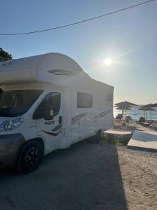 Una caravana blanca estacionada en la playa con el océano. en Camper Rent motorhome Albania, en Tirana