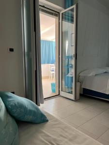 a bedroom with a bed and a sliding glass door at B&B Villa Méditerranée con park in Trani