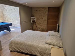 a bedroom with a bed and a pool table at La Maison de Condé in Conde-sur-Ifs