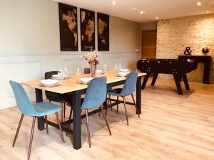 a dining room with a table and a piano at La Maison de Condé in Conde-sur-Ifs