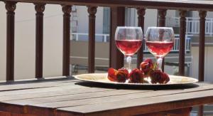 two glasses of wine and roses on a table at House Chrysoula Mitsokopi in Sarti