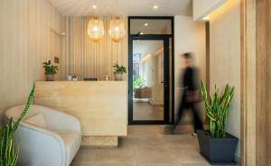 a person walking through a lobby with a reception counter at The Residence Christokopidou Hotel & Spa in Athens +31 photos