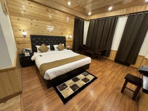 1 dormitorio con 1 cama grande en una habitación de madera en Hotel Black Magic en Manāli
