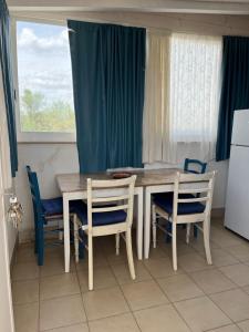 a kitchen with a table and chairs and a window at B&B Villa Méditerranée con park in Trani