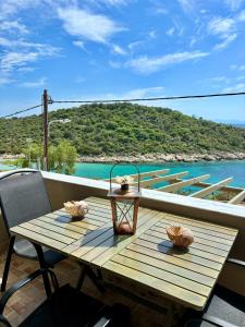 una mesa de madera en un balcón con vistas al agua en Manti en Skála Marión