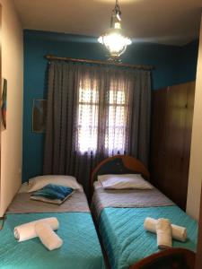two twin beds in a room with blue walls at Talos House in Rakhónion