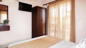 a bedroom with a bed and a large window at House Chrysoula Mitsokopi in Sarti