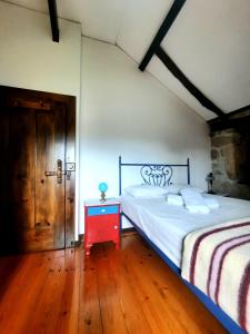 sypialnia z dużym łóżkiem i czerwonym stołem w obiekcie Casa do Tarrão 