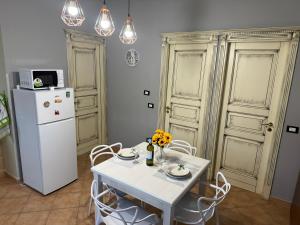 kuchnia z białym stołem i lodówką w obiekcie Casa del mare Mely w mieście Ficarazzi