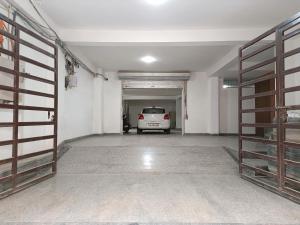 un garage avec une voiture blanche garée à l'intérieur dans l'établissement Hotel Triton Grand At Delhi Airport, à New Delhi