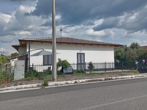 a white house with a fence next to a street at Beb Da Tina in Roccasecca