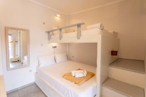 a small bedroom with a bunk bed and a mirror at Eressian Lodgings, Skala Eressos Beach in Skala Eresou