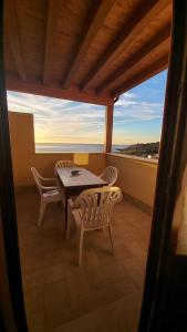 a table and chairs on a balcony with a view at Alykè Appartamenti Vacanze Macari in Macari