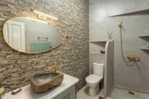 ein Bad mit einem Waschbecken und einem Spiegel in der Unterkunft Eressian Lodgings, Skala Eressos Beach in Skala Eresou