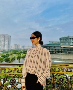 a woman wearing sunglasses standing on a balcony at Marina Hotel Ha Noi in Hanoi