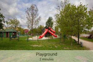 un parque infantil con un tobogán rojo en un parque en Outdoor Adventure Smart Riverside Pet Friendly, en Budapest