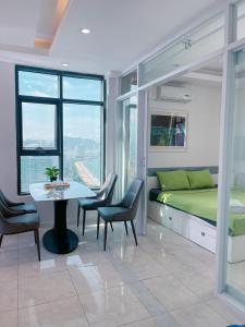 - une chambre avec un lit, une table et des chaises dans l'établissement Gold Beach Nha Trang Apartment, à Nha Trang