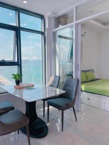 comedor con mesa, sillas y cama en Gold Beach Nha Trang Apartment, en Nha Trang
