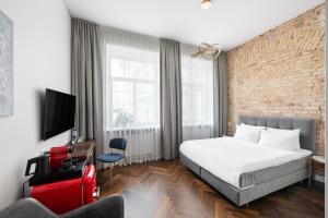 sypialnia z łóżkiem i ceglaną ścianą w obiekcie GRAND CROWN w Wilnie