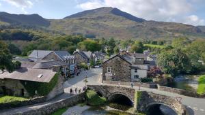 an aerial view of a village with a bridge and mountains at Plas Tan y Graig B&B Guest House Beddgelert in Beddgelert