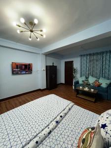 een woonkamer met een groot bed en een bank bij Bluebird'snest in Gangtok