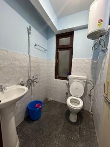 een badkamer met een wit toilet en een wastafel bij Bluebird'snest in Gangtok
