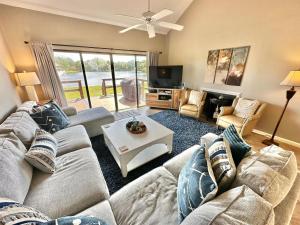 Una sala de estar con un sofá y un televisor. en 5191 Beachwalk, en Destin