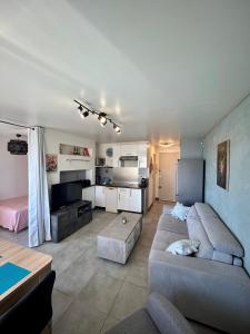 sala de estar amplia con sofá y cocina en [Vue Mer] Beau 2pièces, proche plage, centre-ville, en Cannes