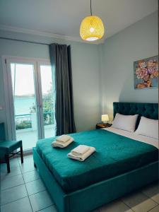 Villa Violeta Lefkada Nydri في نيدري: غرفة نوم بسرير اخضر كبير عليها مناشف
