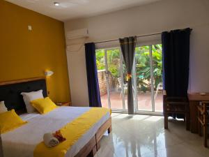 um quarto com uma cama e uma grande janela em Hotel Les Cygnes em Antananarivo