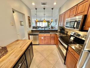 una cocina con armarios de madera y encimeras negras en 5197 Beachwalk, en Destin