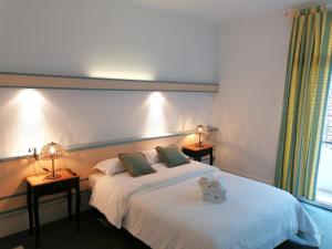 Hôtel Restaurant Aux Armes D'Estaing - KB HOTEL GROUP في إستين: غرفة نوم مع سرير مع دمية دب عليها
